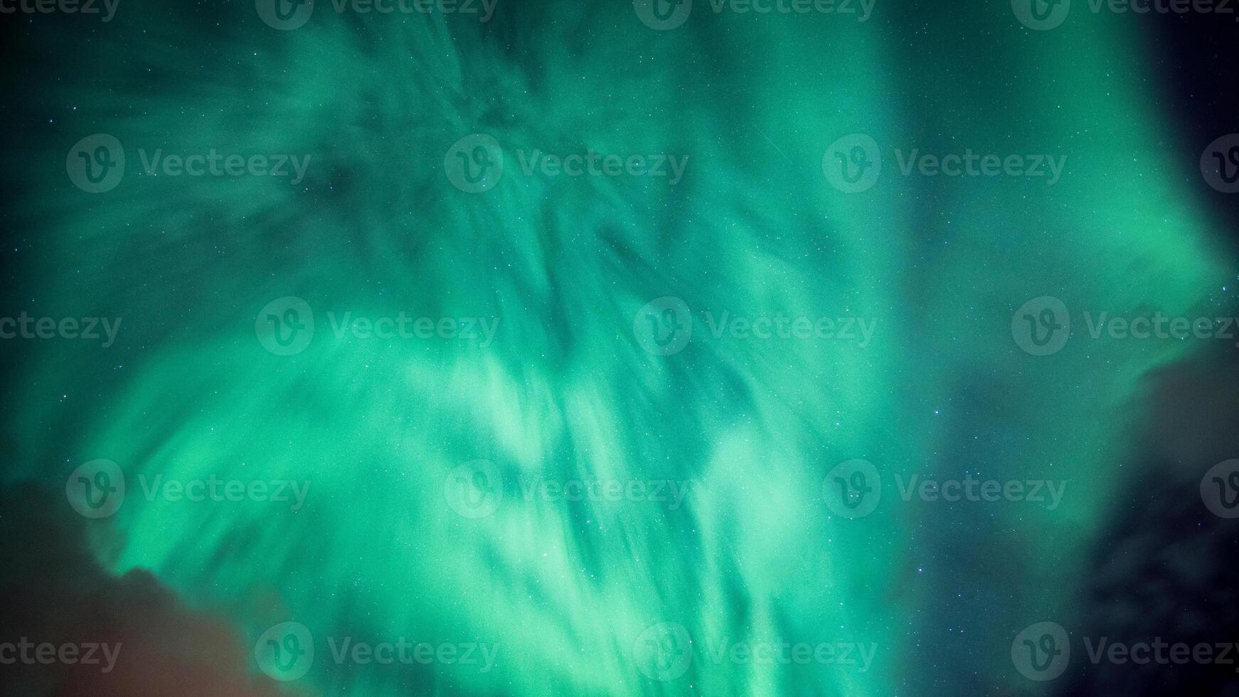 Bright and active Aurora borealis or Northern lights glowing in the night sky on Arctic circle photo
