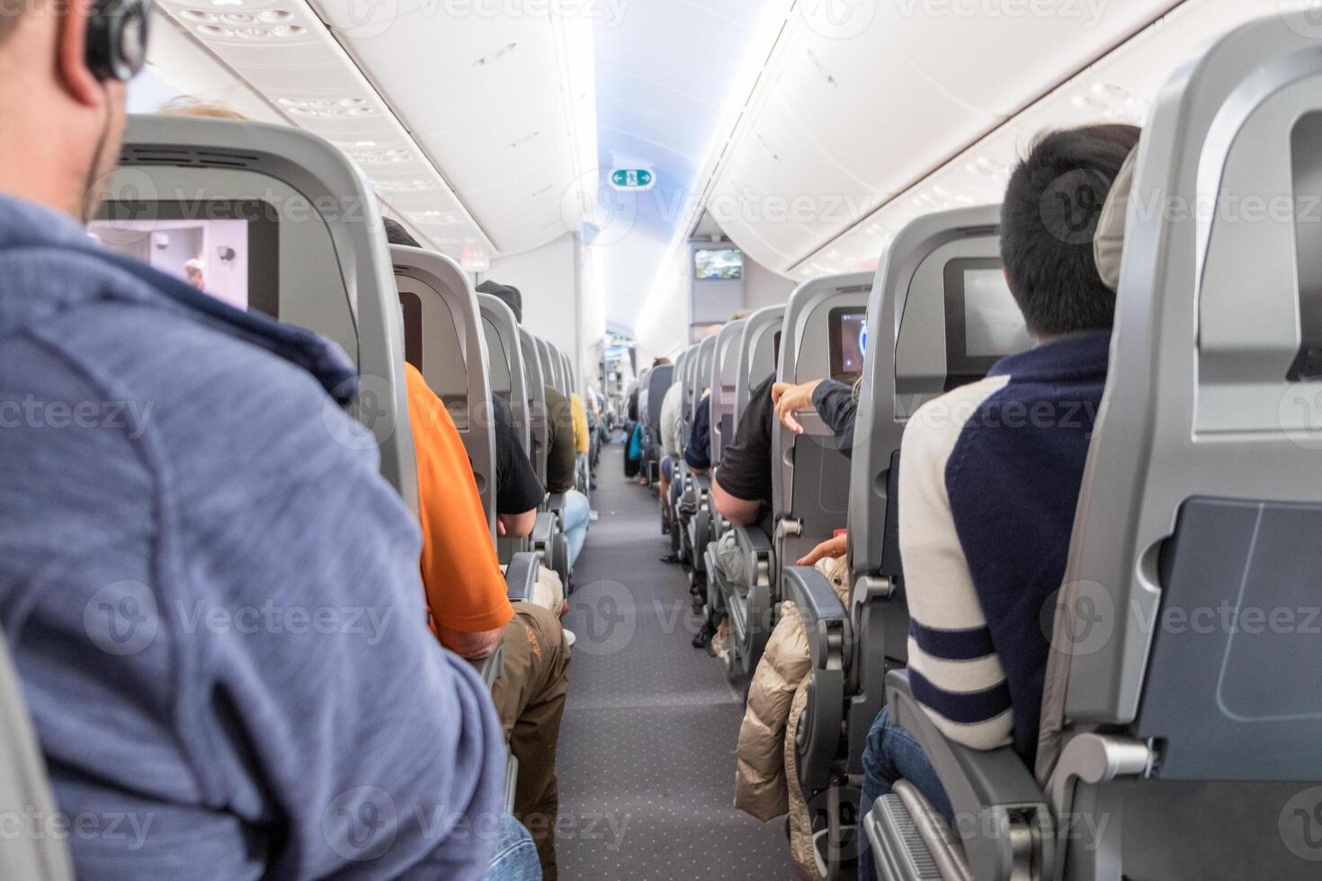 Unidentified passengers sitting on seats in airplane photo