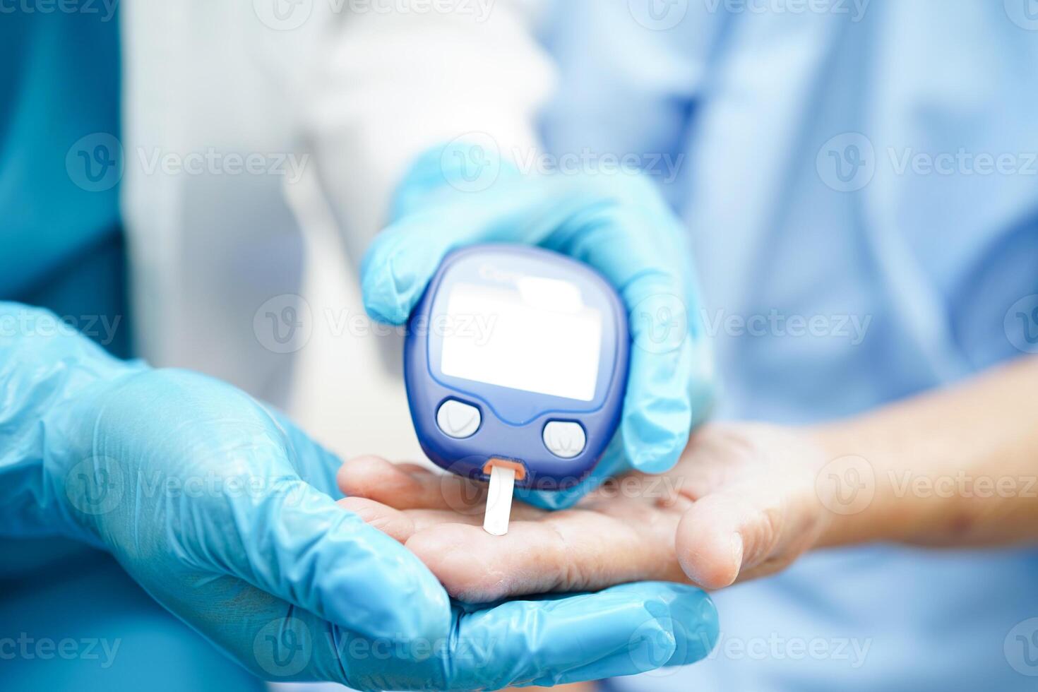 Asian doctor using digital glucose meter for check sample blood sugar level to treatment diabetes. photo