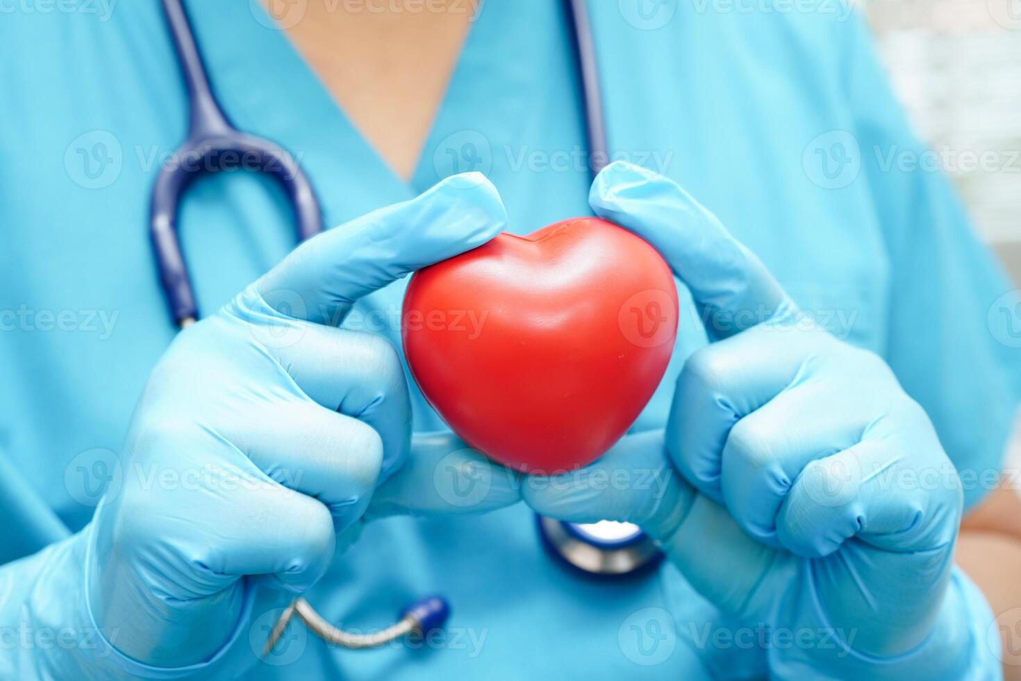 Asian woman doctor holding red heart for health in hospital. photo