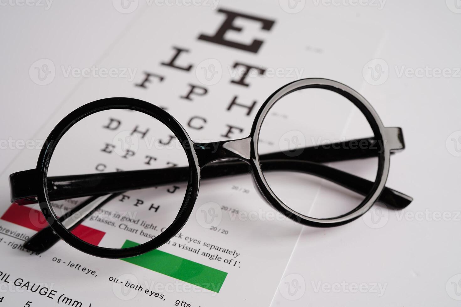 Glasses on eye exam chart to test eyesight accuracy of reading. photo