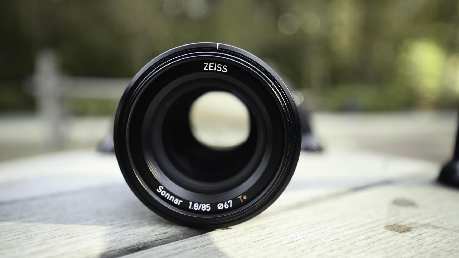 Germany, Berlin - August 15, 2022. Close-up camera lens. Action. Lens for professional camera on blurry street background. New lens model for photo shooting