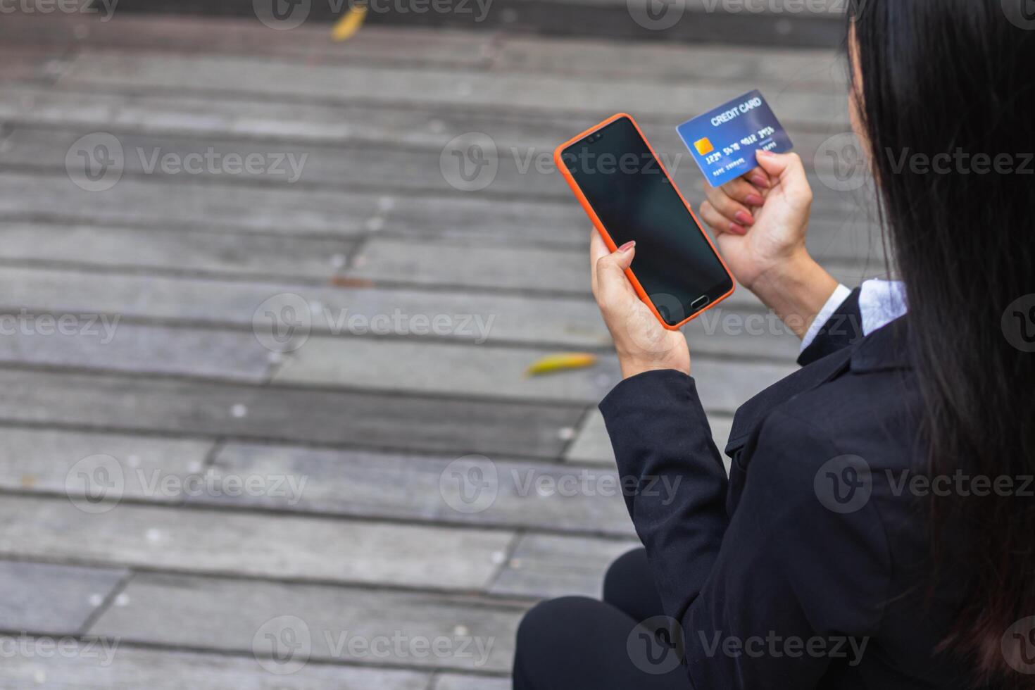 Young woman is shopping online through mobile application by paying with her credit card Convenience of paying through shopping online. Concept of online shopping and spending through credit card. photo