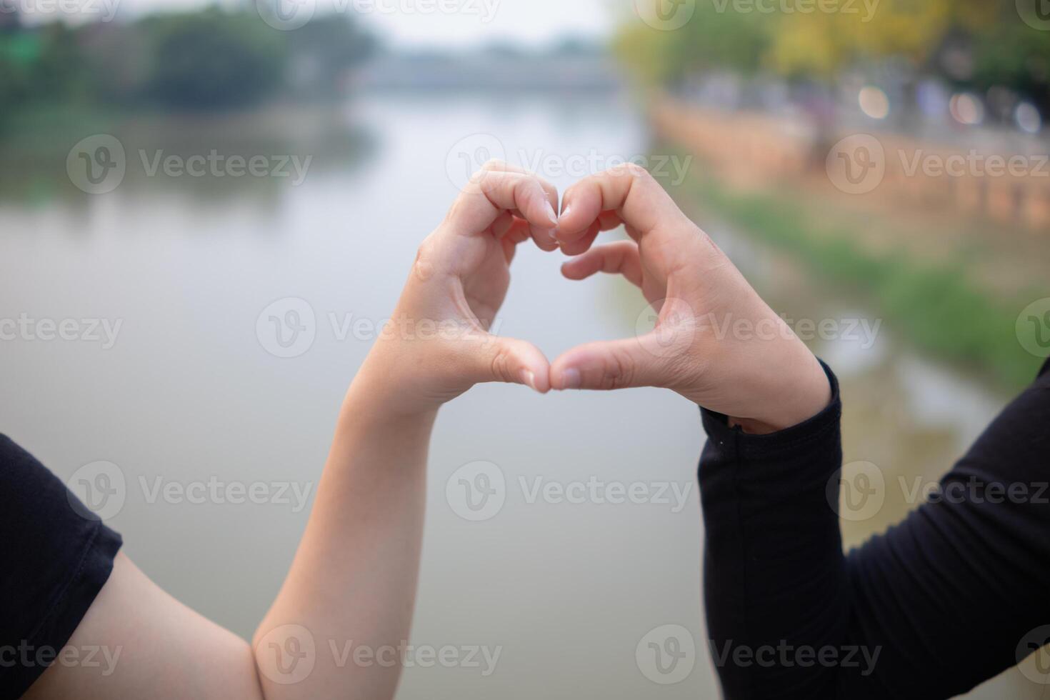 woman raised her hands and made heart symbol to express meaning of love friendship and kindness to her friends and lovers. woman uses her hands to make a heart symbol that means love and friendship. photo