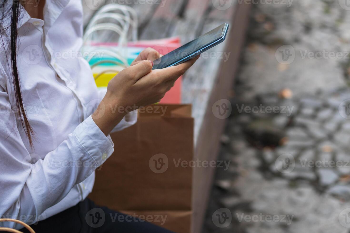 Young woman is shopping online through mobile application by paying with her credit card Convenience of paying through shopping online. Concept of online shopping and spending through credit card. photo