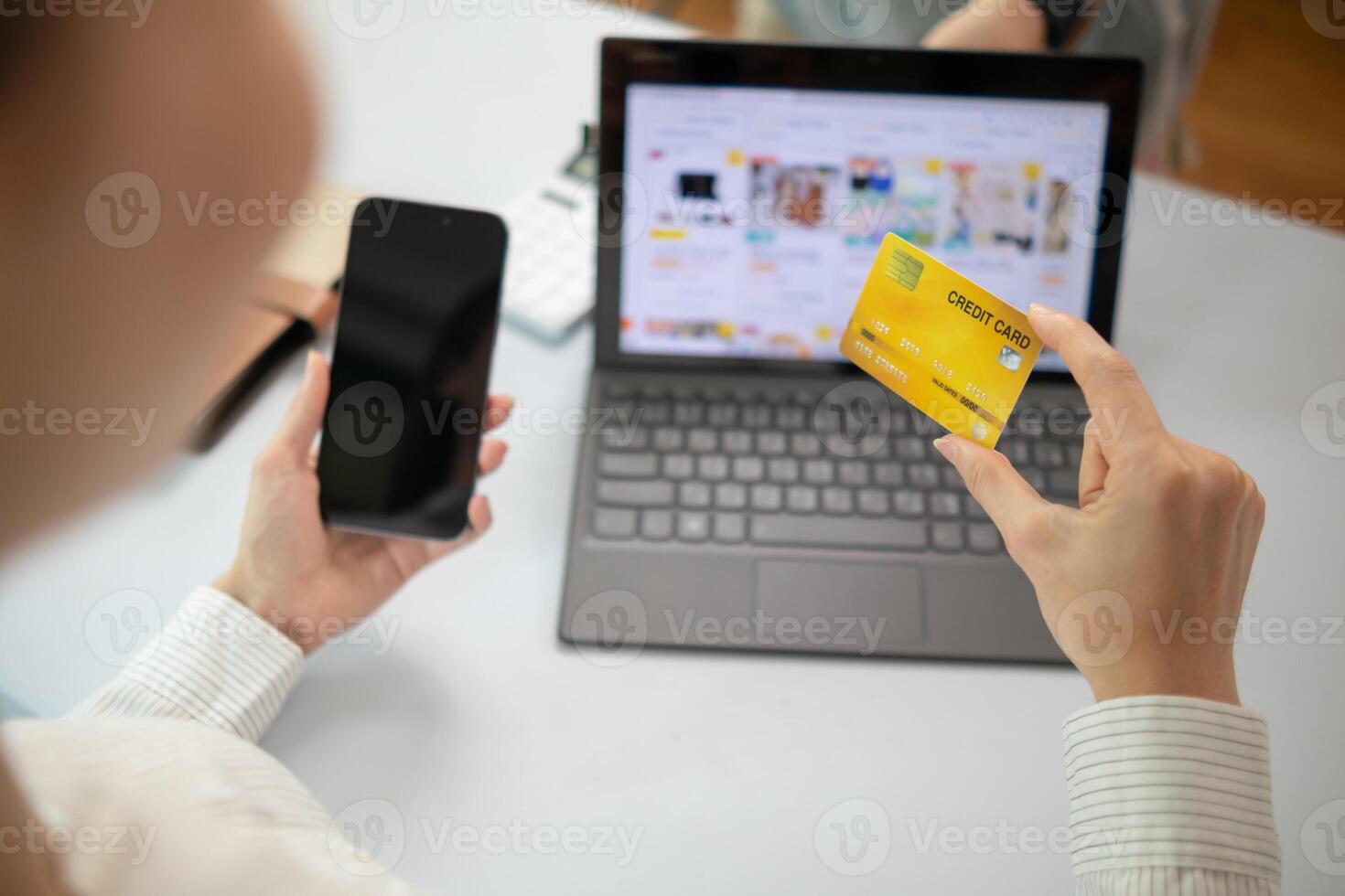 Young woman is shopping online through mobile application by paying with her credit card Convenience of paying through shopping online. Concept of online shopping and spending through credit card. photo