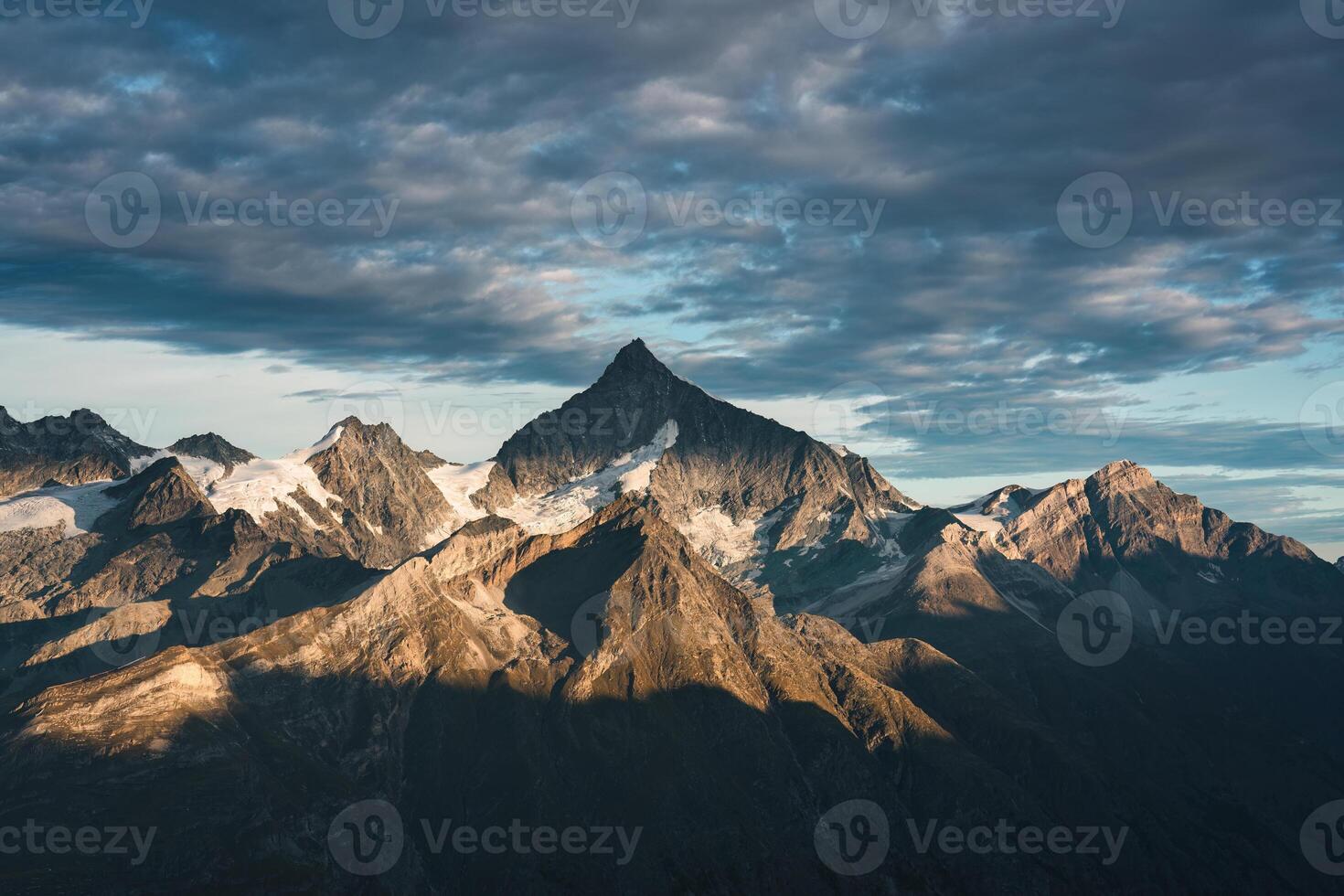 Rocky mountain with cloudy sky on summit in Swiss Alps photo