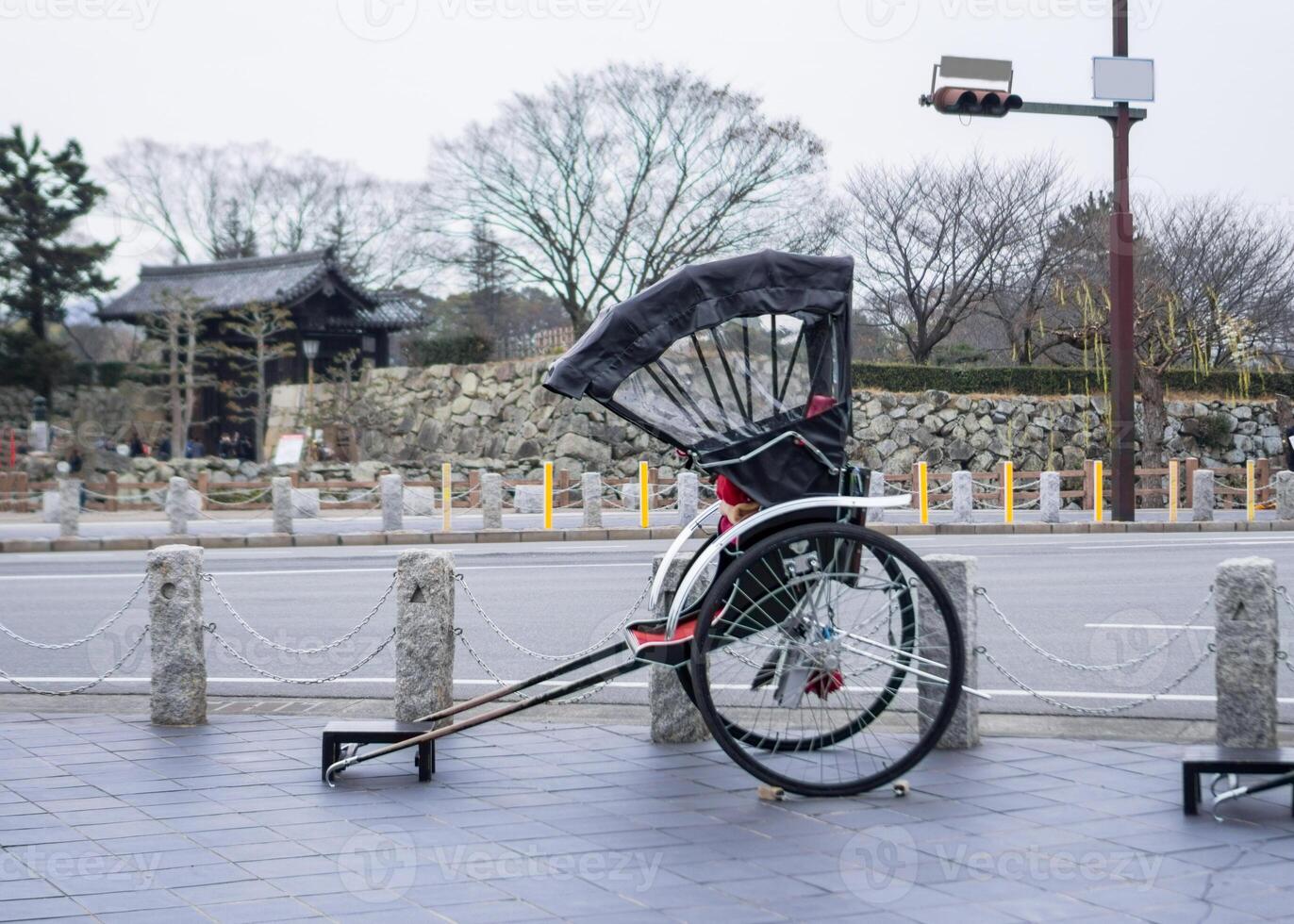 Ancient traditional japanese rickshaw parked on footpath photo