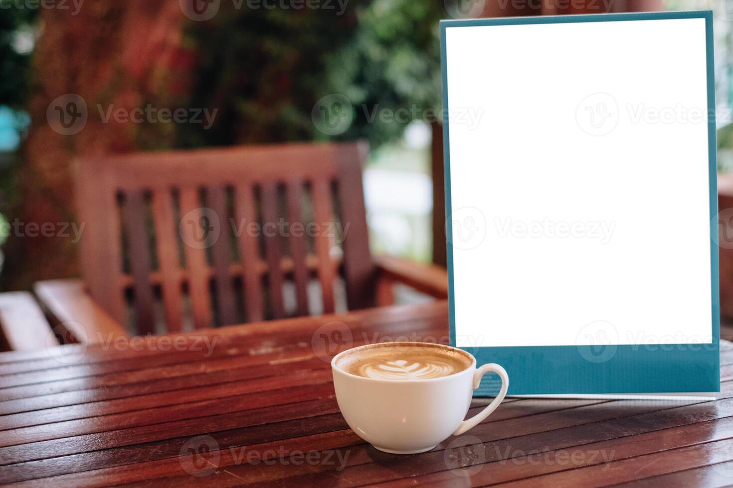 White coffee latte cup with blank signboard on wooden desk photo