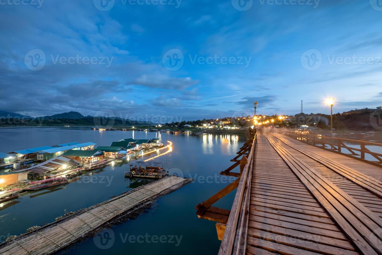 famoso de madera Lun puente con tradicional pueblo en sangkhlaburi a crepúsculo foto