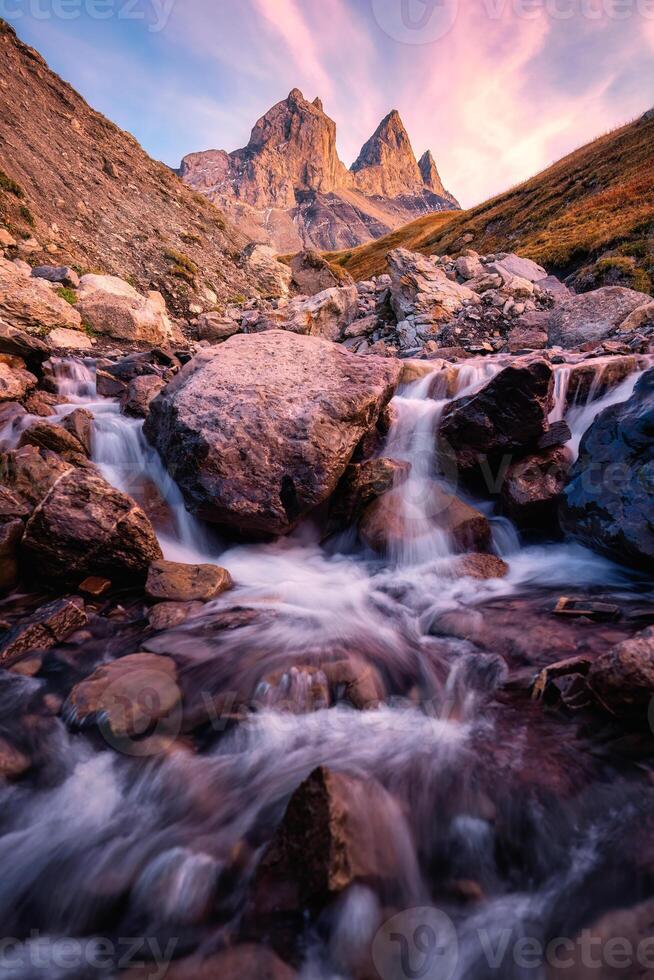 Aiguilles d'Arves with iconic mountain and waterfall flowing in French Alps photo