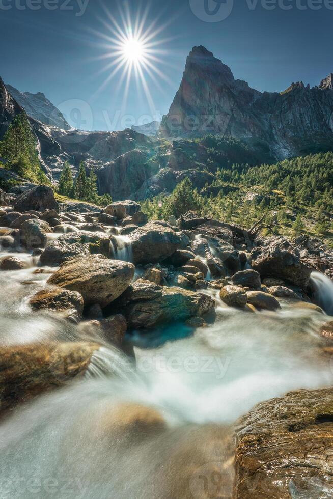 suizo Alpes de wetterhorn pico con rayos de sol brillar y cascada fluido en soleado día a Reichenbach, rosenlaui, Suiza foto