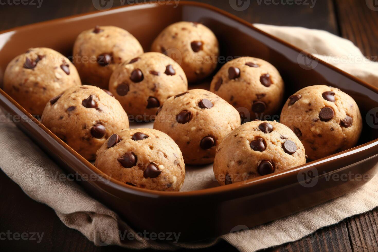 AI generated Baking pan with raw chocolate chip cookie balls on table, closeup photo