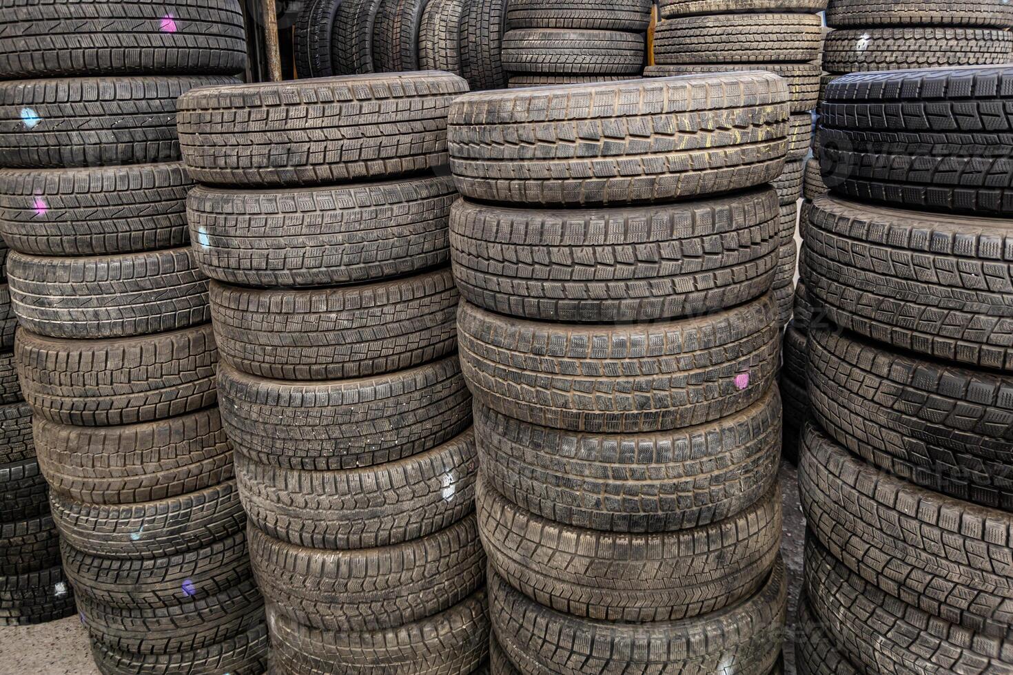 AI generated stacks of used good condition tires for cars, close full-frame background photo