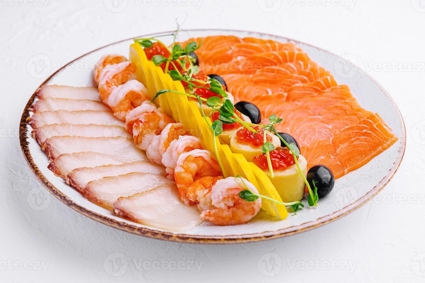 salmon, white fish, shrimp and red caviar on plate photo