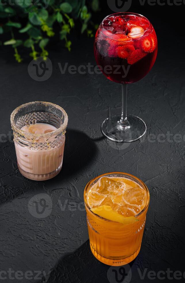 Glasses of cold infused water with fresh orange and strawberry slices and iced coffee photo