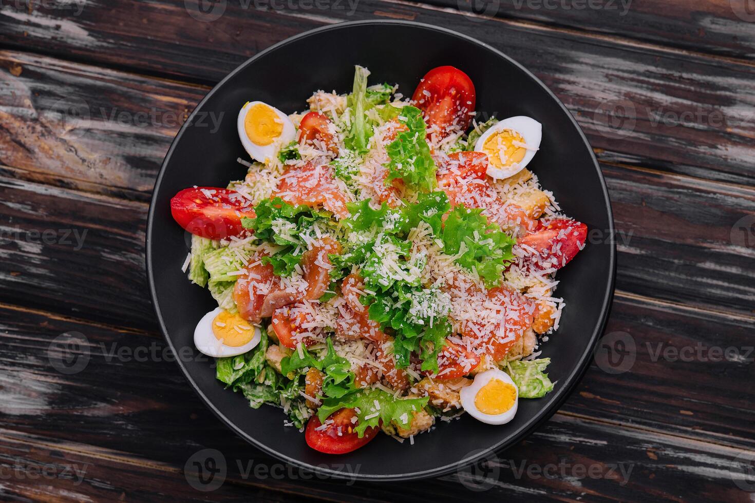 Salad with salmon, lettuce, boiled eggs, cherry tomatoes and parmesan cheese photo
