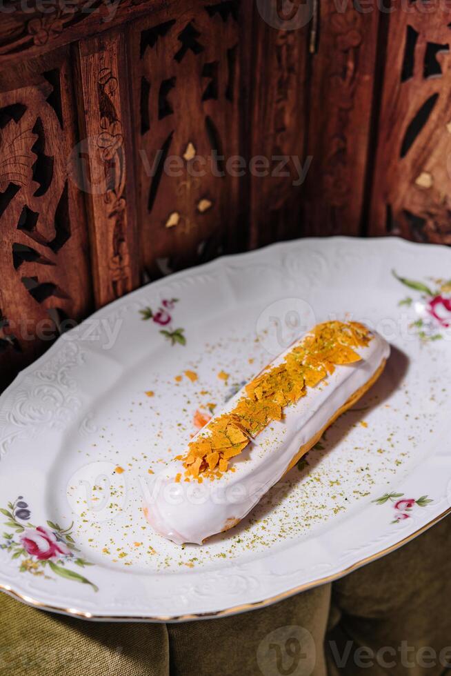 Close up of eclair with white cream and chips photo