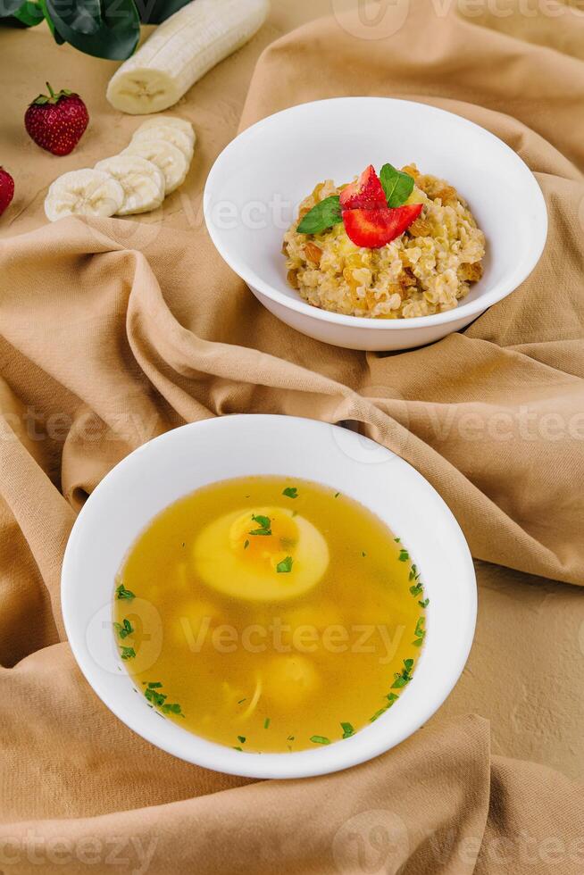 hot soup with meatballs and oatmeal with banana photo