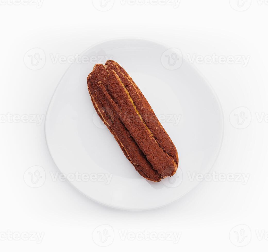 delicious chocolate French eclair on plate photo
