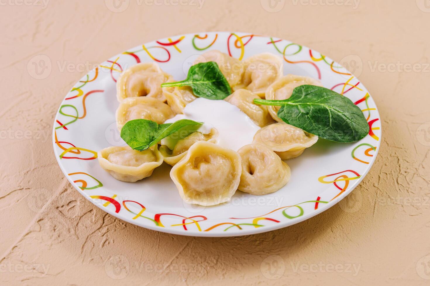 Boiled dumplings with basil on plate photo