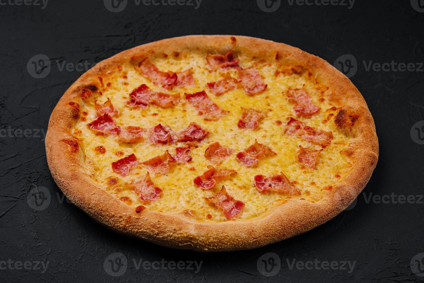 Pizza con tocino y queso en Roca tablero foto