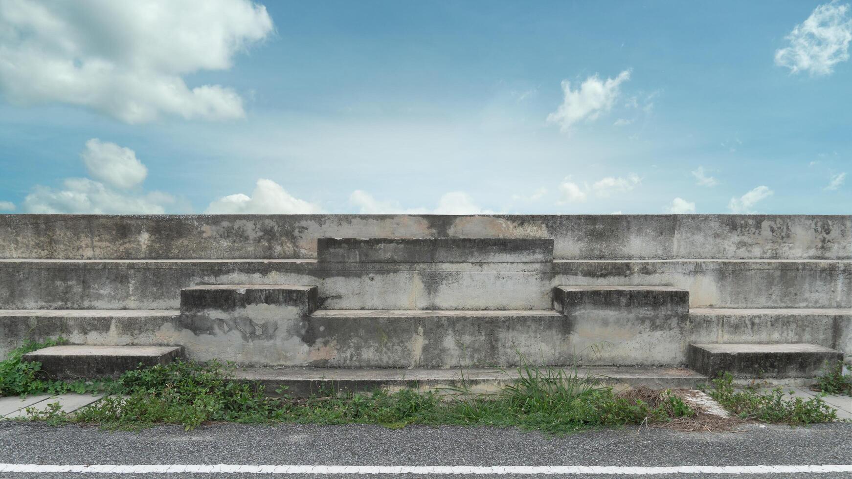 Building of cheering grandstand mix with award podium. Front gound of asphalt floor and green grass. Background of blue sky and white clouds. photo