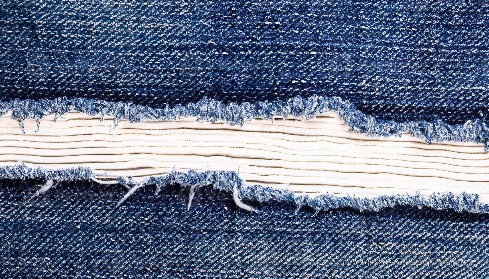 AI generated A close-up of a torn section in blue denim fabric, revealing the white threads underneath photo