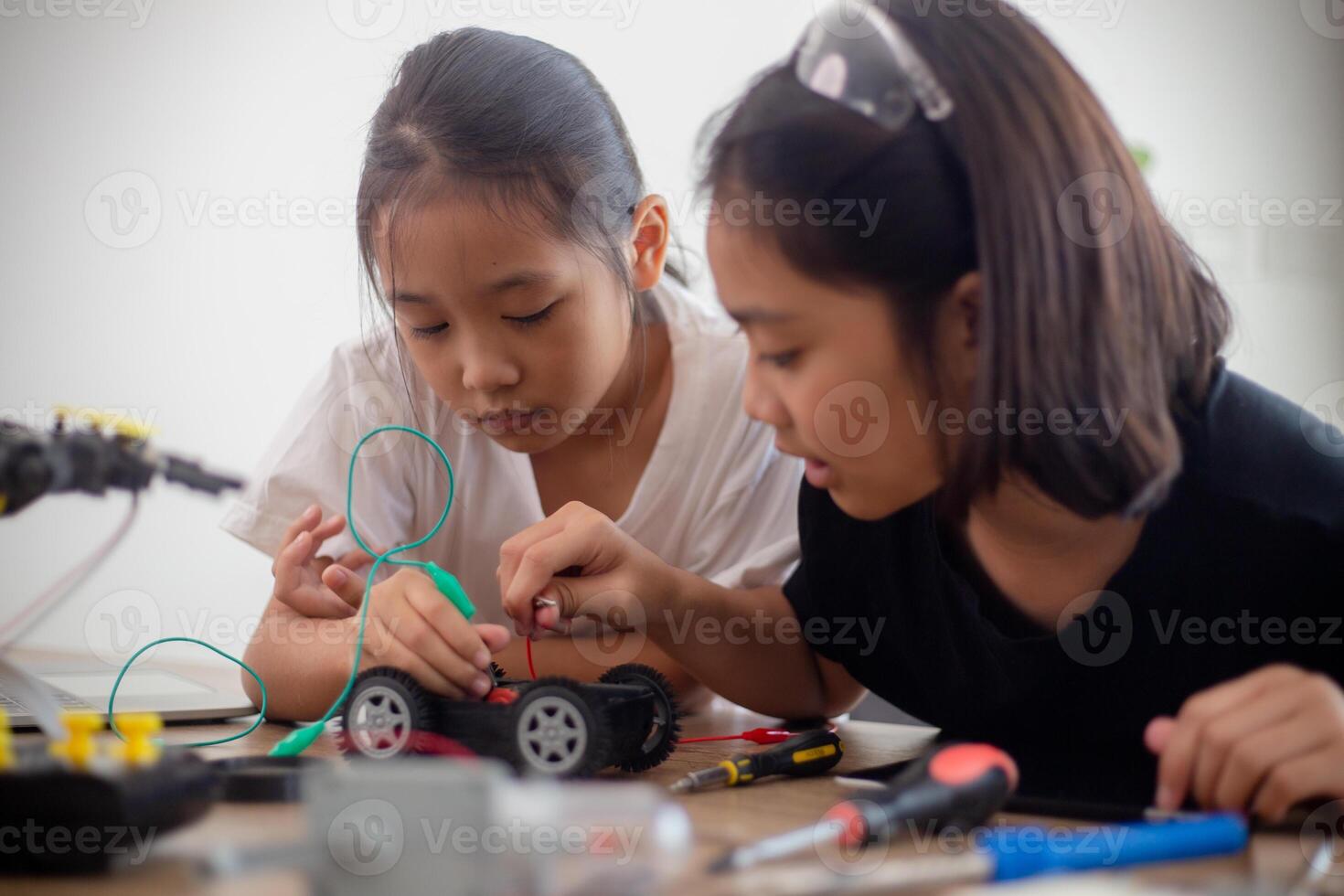 inventivo niños aprender a hogar por codificación robot carros y electrónico tablero cables en provenir. construyendo robot carros a hogar foto