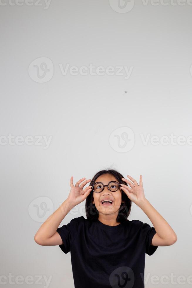 cute little preschooler girl isolated on grey studio background wear glasses look at camera, small child try spectacles at opticians, kid eyesight correction treatment concept photo