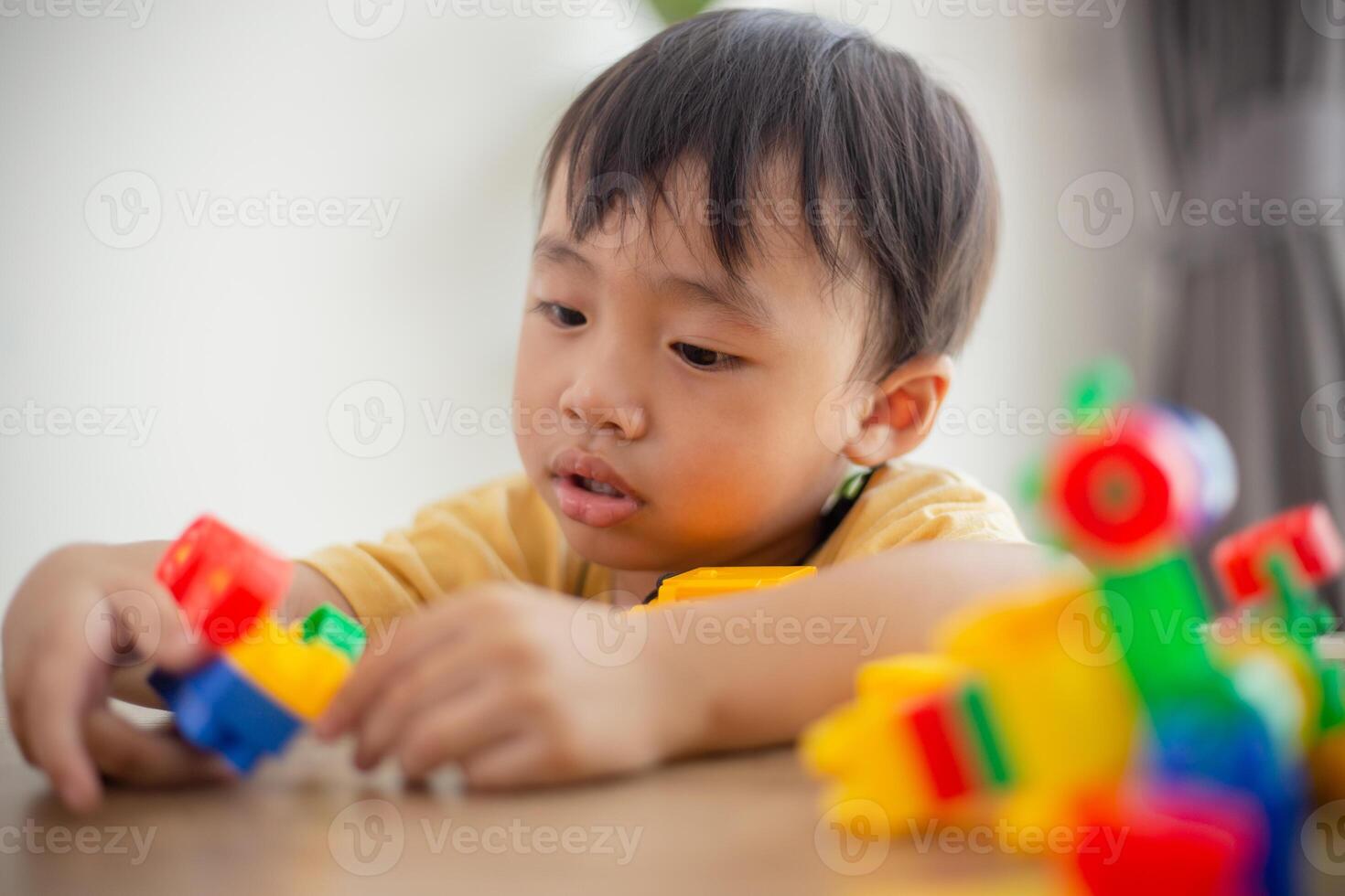 Cute little boy playing with colorful toys photo