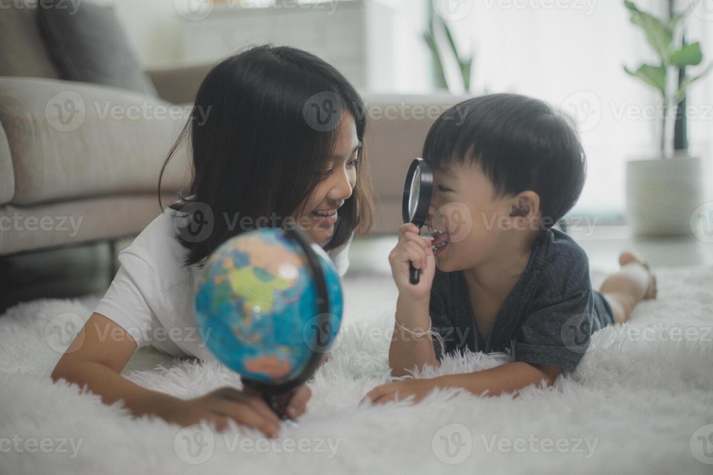 asiático pequeño muchachas y Niños son aprendizaje el globo modelo, el concepto de salvar el mundo, y aprendizaje mediante jugar ocupaciones para niño educación a hogar. foto