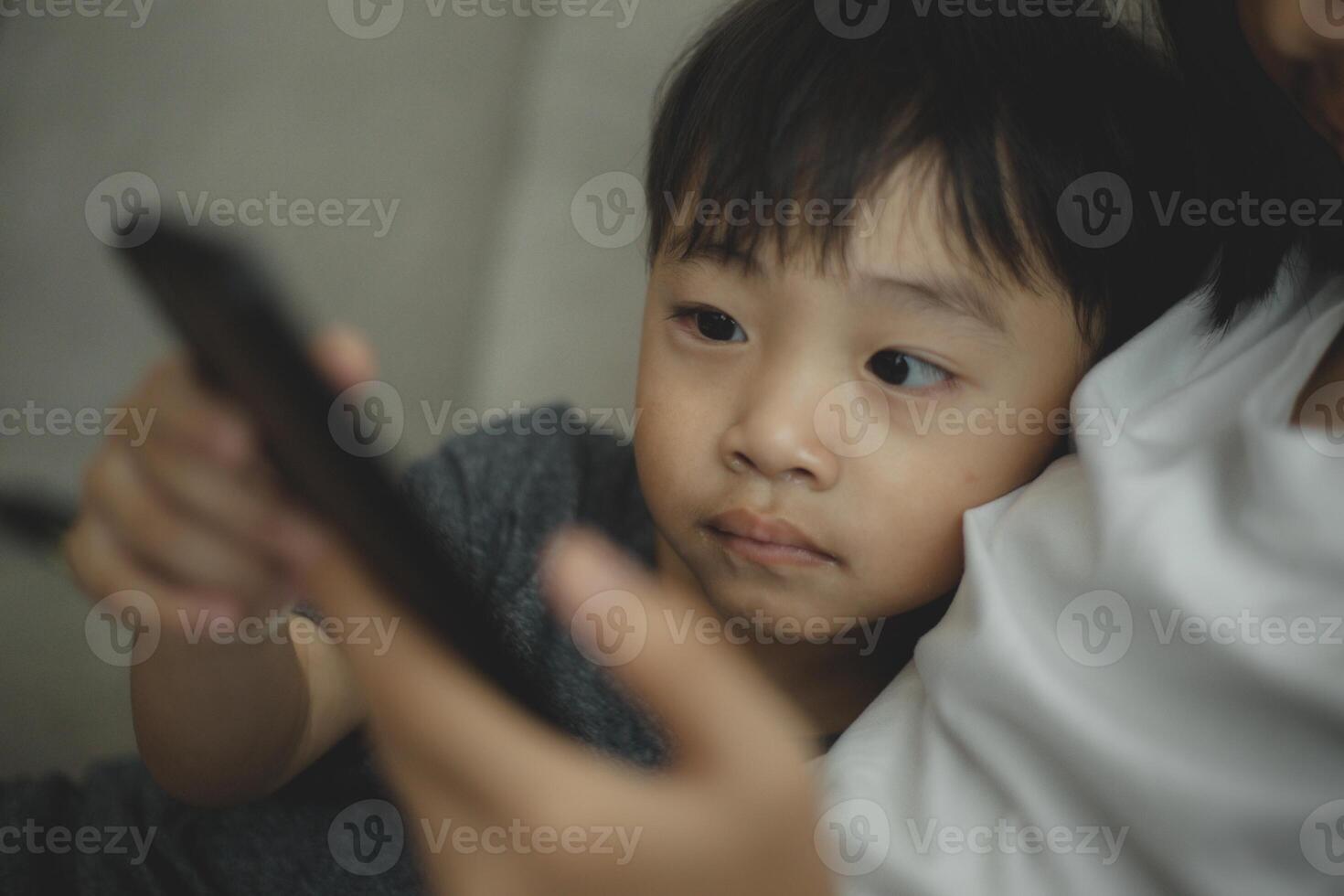 Child-addicted phone concepts. Asian boy playing smartphone, kid use telephone, watching smartphone. photo