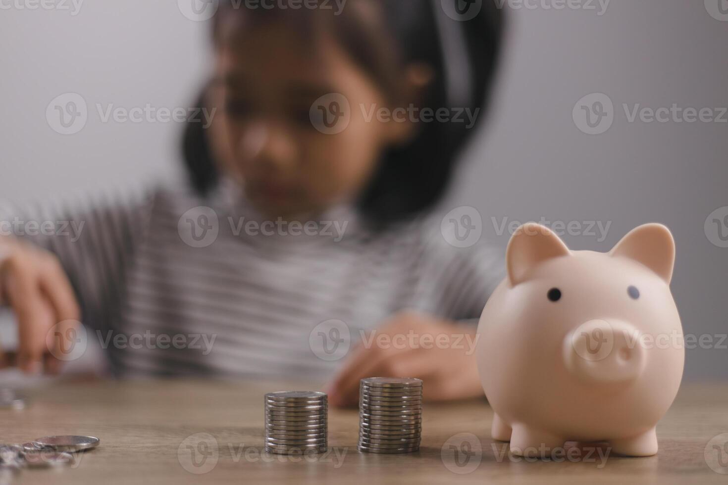 Little Asian girl saving money in a piggy bank, learning about saving, Kid save money for future education. Money, finances, insurance, and people concept photo