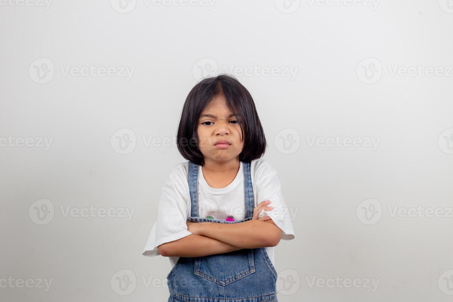 Angry little girl over white background, sign and gesture concept photo