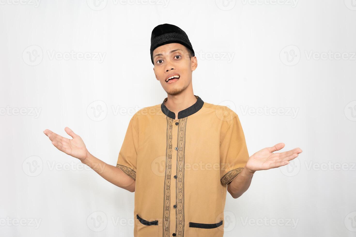 Muslim Asian man wearing brown Muslim shirt feeling confused or not knowing. Isolated white background. photo