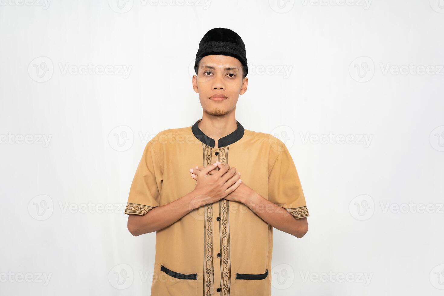 asiático musulmán hombre vistiendo musulmán ropa es Orando o calmante su corazón. aislado blanco antecedentes. foto