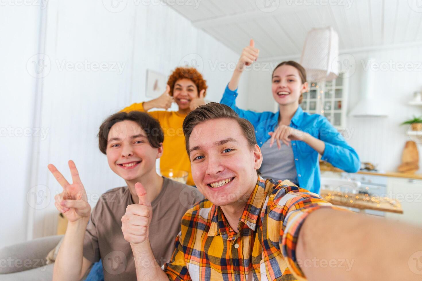 Cheers Funky mood. Happy friends make selfie. Man taking photo of friends at party. Group of multiracial people taking photo on phone. Young people enjoy their company smile have fun. Webcamera view