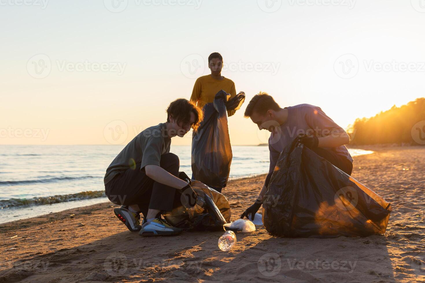 tierra día. voluntarios activistas recoge basura limpieza de playa costero zona. mujer y mans pone el plastico basura en basura bolso en Oceano costa. ambiental conservación costero zona limpieza foto