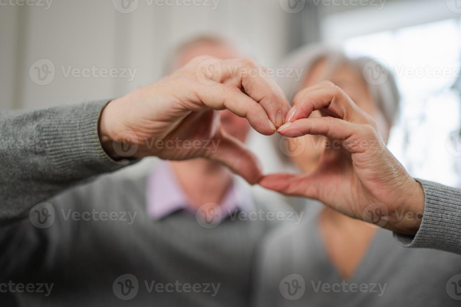 Love heart shape peace. Senior older couple making heart shape with their hands. Adult mature old husband wife showing heart sign. Happy pensioner family. I love you happy valentines day photo
