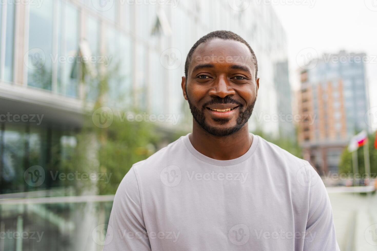 Happy african american man smiling outdoor. Portrait of young happy man on street in city. Cheerful joyful handsome person guy looking at camera. Freedom happiness carefree happy people concept photo