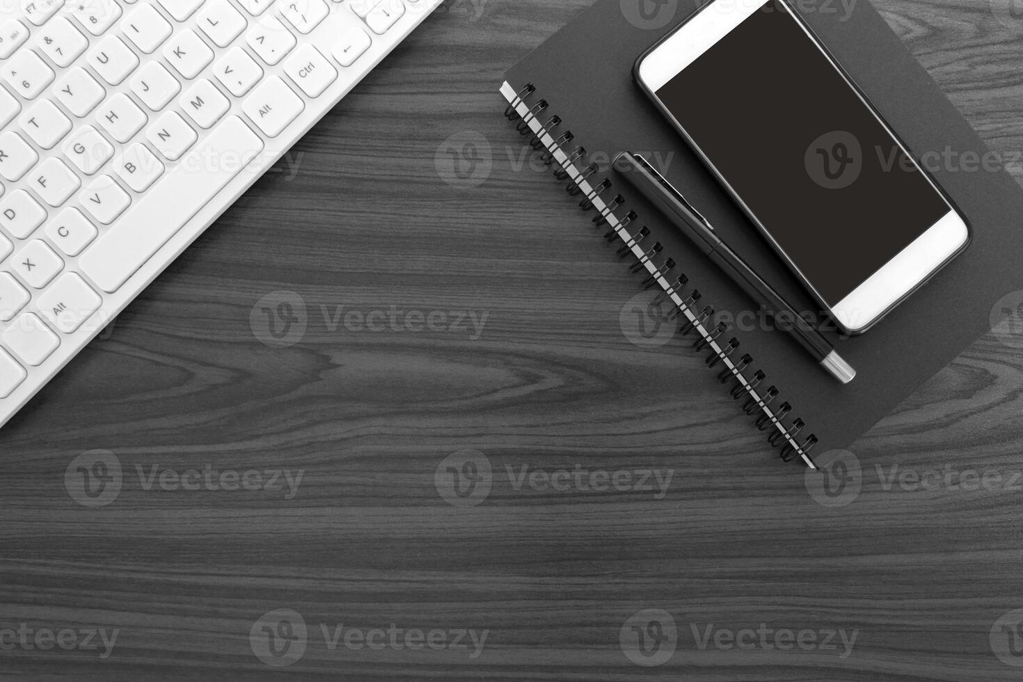 Home office workspace with white keyboard, note books, pen and smartphone. photo