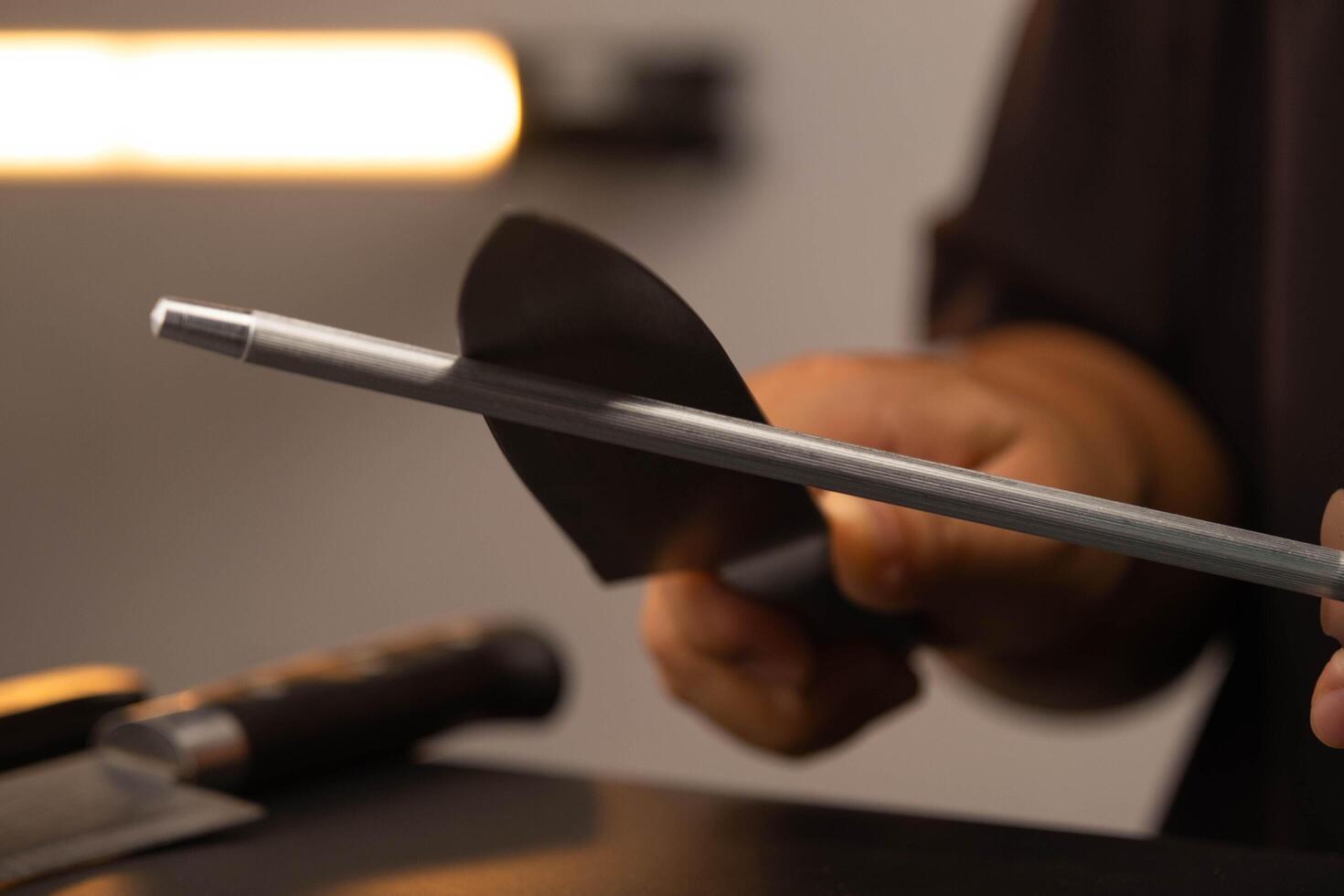 Close-up of female chef sharpening knives. Sharpen knives with a whetstone or grinding stone. Woman using a knife grinder, Hands sharpening knives in the kitchen. photo