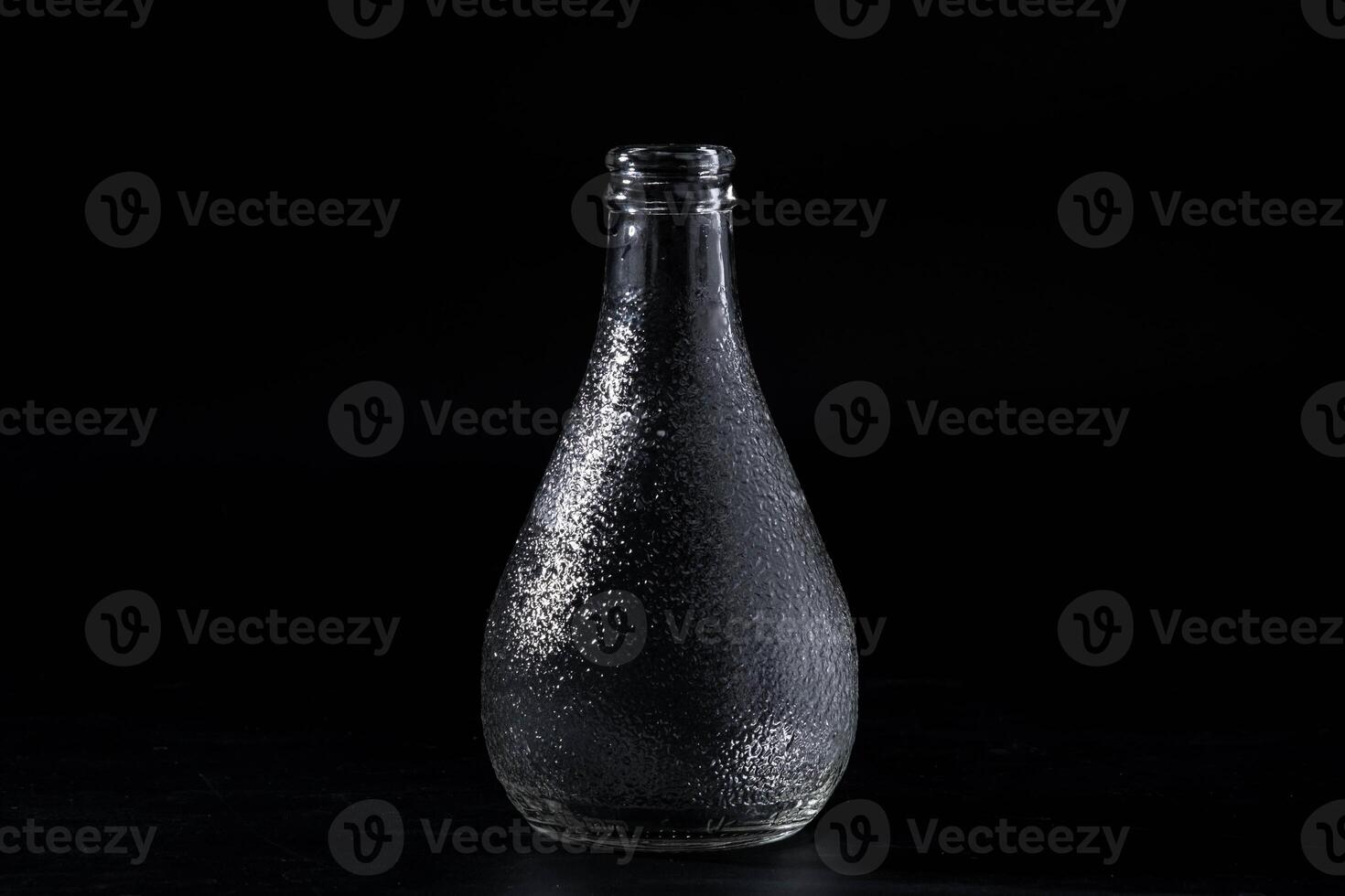 Empty glass bottle isolated on black background. photo