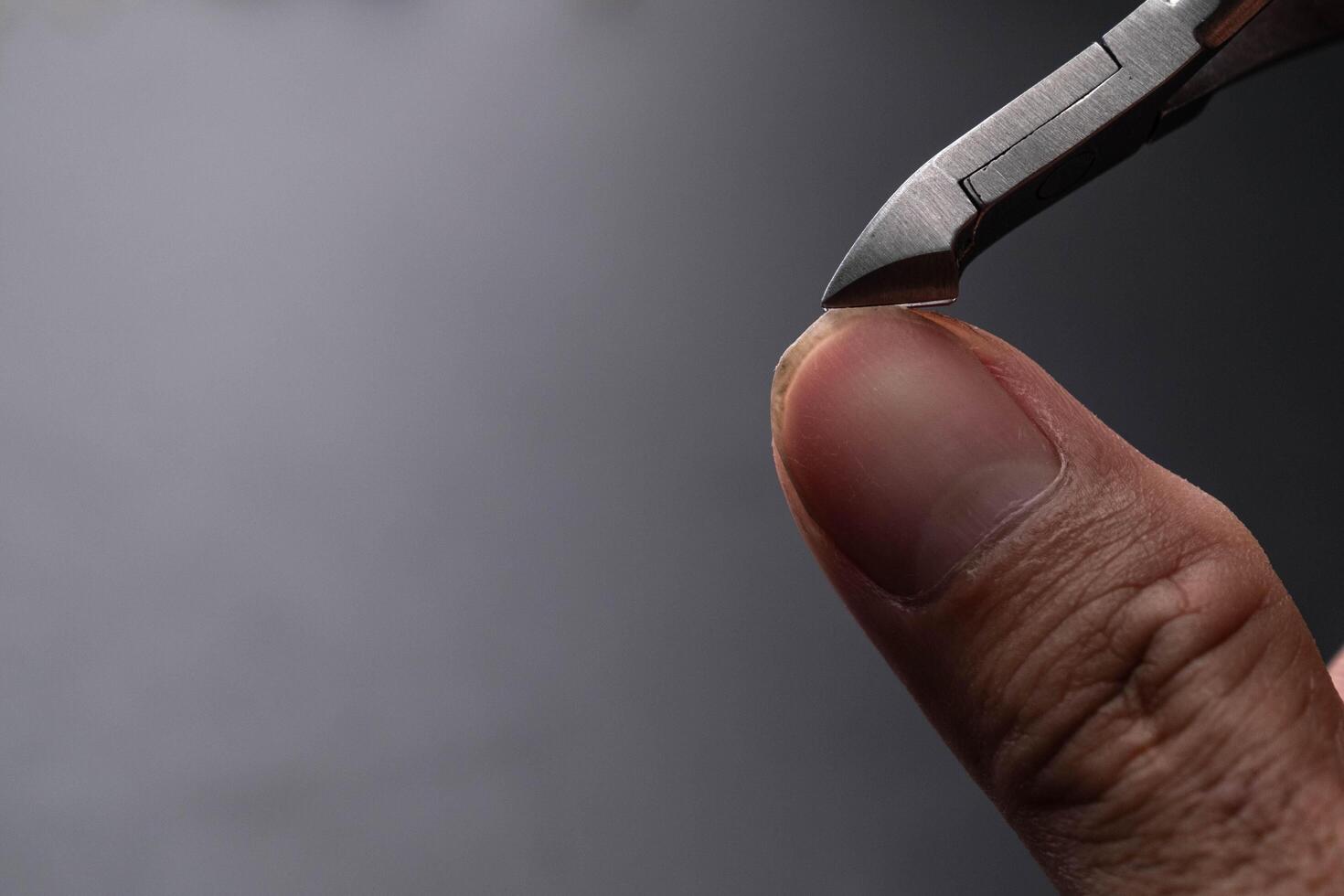 Close-up of cutting nails. Hands are cutting nails using nail clippers. photo