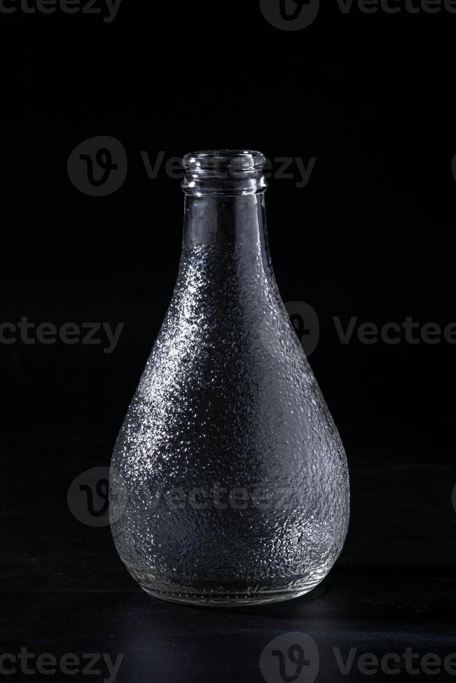 Empty glass bottle isolated on black background. photo