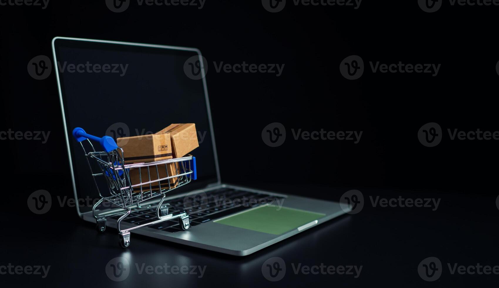 Boxes in a shopping car on a laptop keyboard. Ideas about online shopping, online shopping is a form of electronic commerce that allows consumers to directly buy goods from seller over the internet. photo