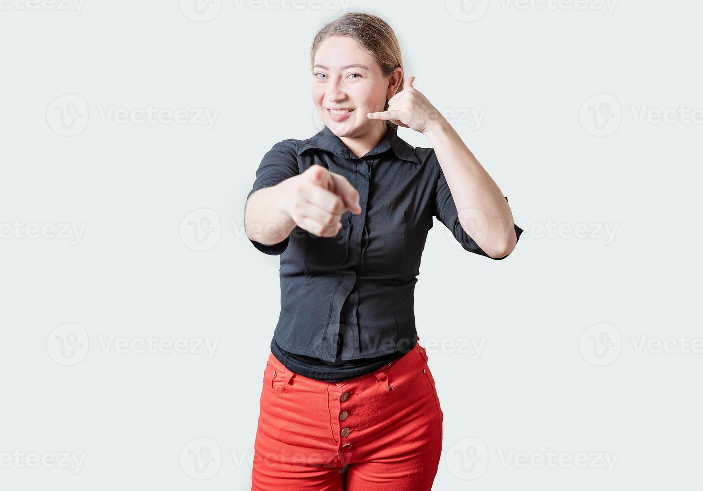 sonriente hermosa mujer gesticulando llamada yo y señalando a cámara. simpático niña gesticulando llamada yo con dedos aislado foto