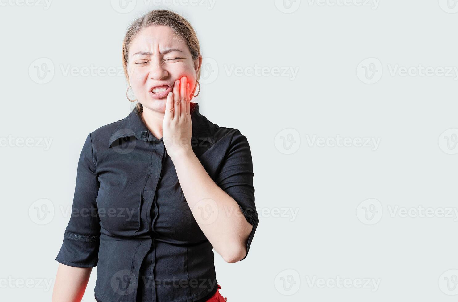 Young woman suffering with toothache isolated. Unhappy girl rubbing cheek with toothache photo