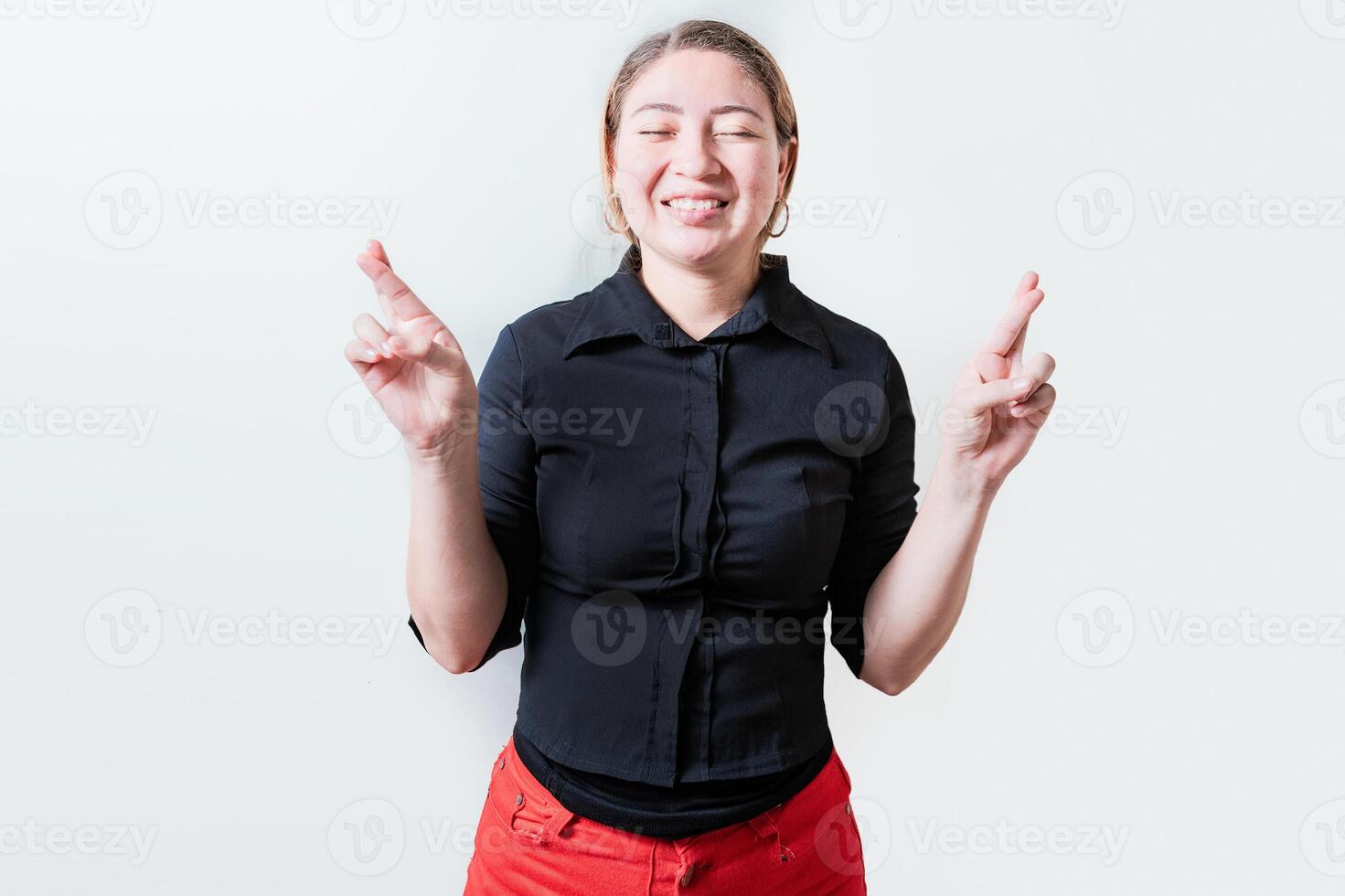 sonriente esperanzado niña haciendo un deseo con su dedos aislado. hermosa sonriente niña cruce dedos haciendo un deseo foto